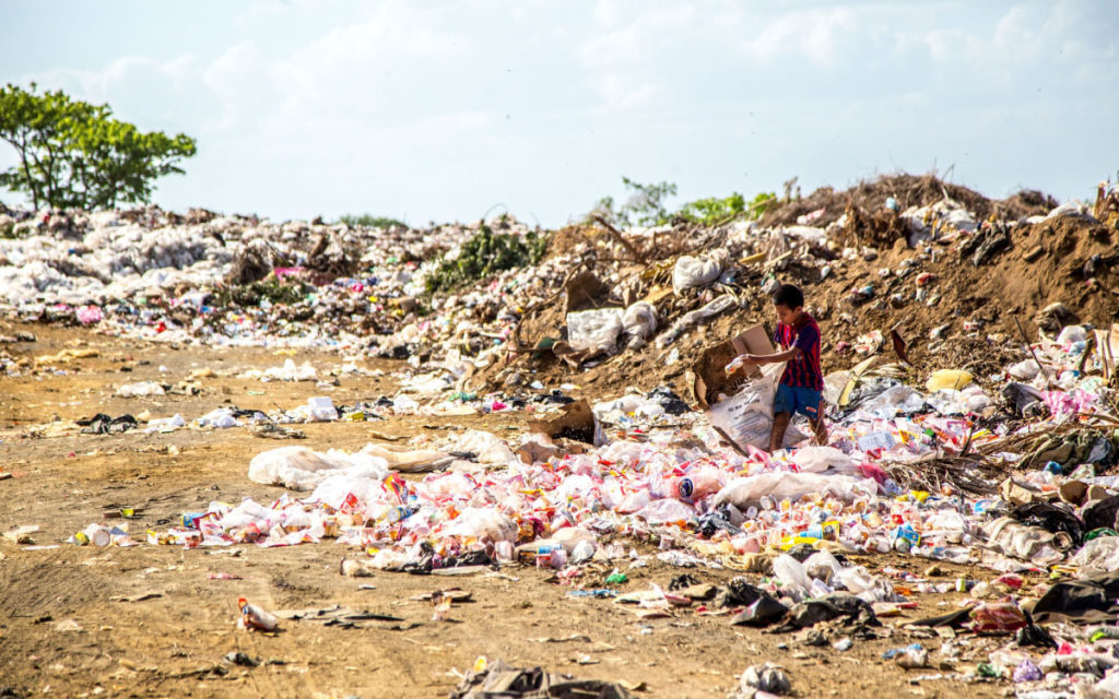 boy collecting trash at Asian landfill